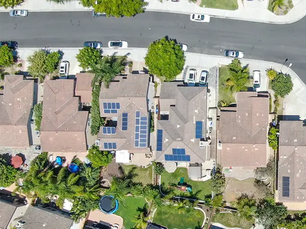 Aerial view of suburban homes with solar panels.